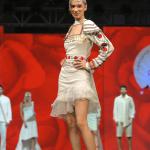 White one-piece with stylish shoulder caps and an embellished belt