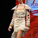 White one-piece with stylish shoulder caps and an embellished belt